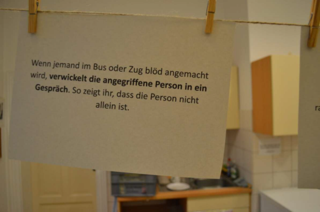 Unser Beitrag im Kreismuseum: Detailfoto von einem Schriftblatt mit dem Text "Wenn jemand im Bus oder Zug blöd angemacht wird, verwickelt die angegriffene Person in ein Gespräch. So zeigt ihr, dass die Person nicht allein ist.